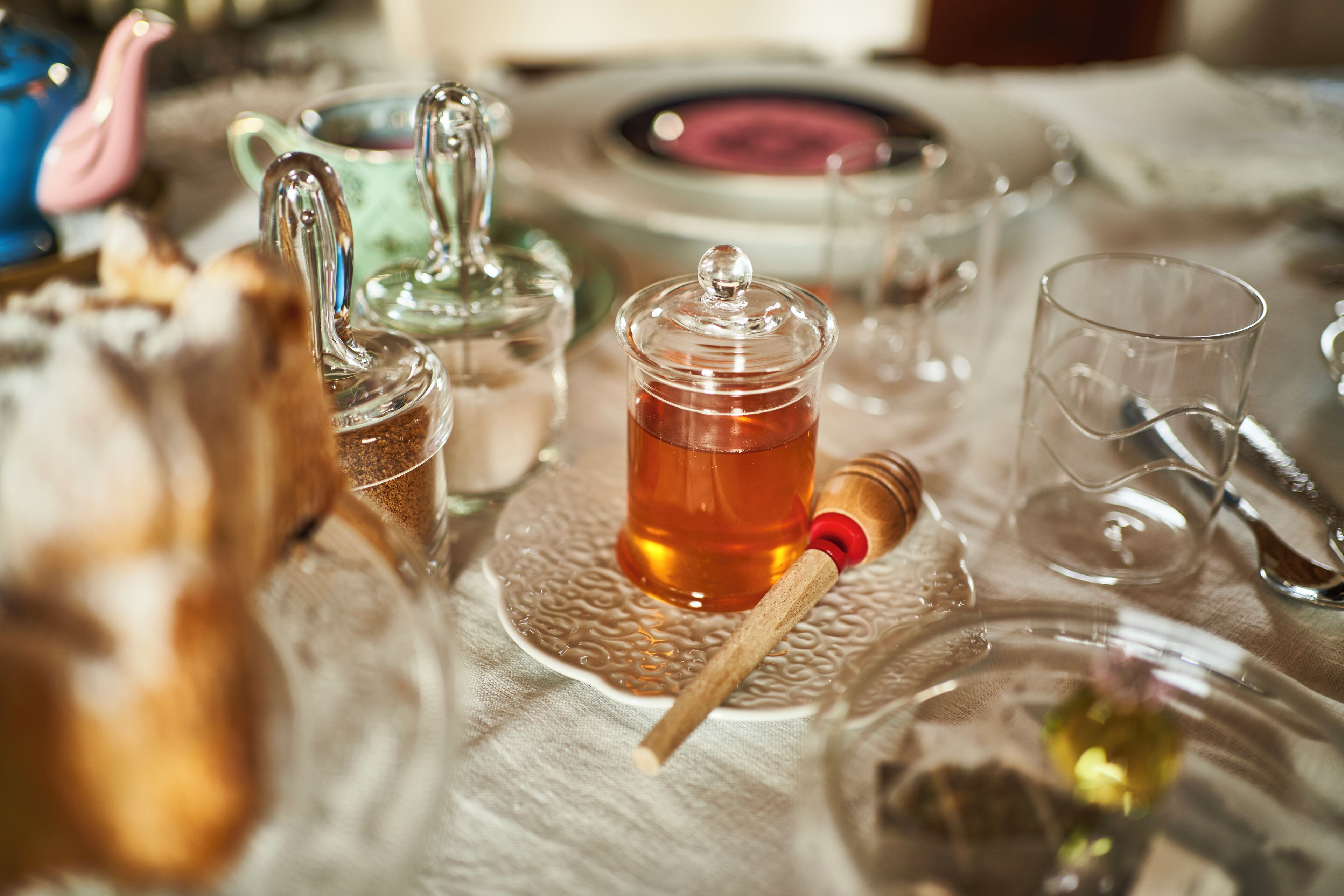 Une table dressée avec différents types de verres et une théière.
