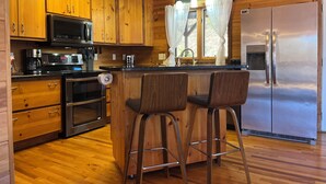 A kitchen with wooden cabinets, a stainless steel refrigerator, a microwave, and a coffee maker.
