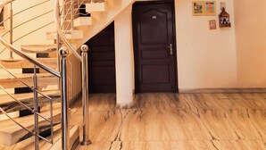 A marble-floored staircase with a metal railing leading to a landing. - Roomshala Hotel Green Valley (New Delhi)