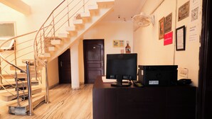 A reception desk with a computer, a telephone, and a framed certificate on the wall. - Roomshala Hotel Green Valley (New Delhi)