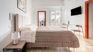 A bedroom with a bed, bedside lamp, and a TV mounted on the wall. - Apartment 'I 4 Venti - Apt 1' with Private Terrace, Wi-Fi and Air Conditioning (Melendugno)