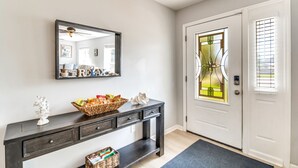 A modern entryway with a dark console table, a mirror, and a decorative basket.