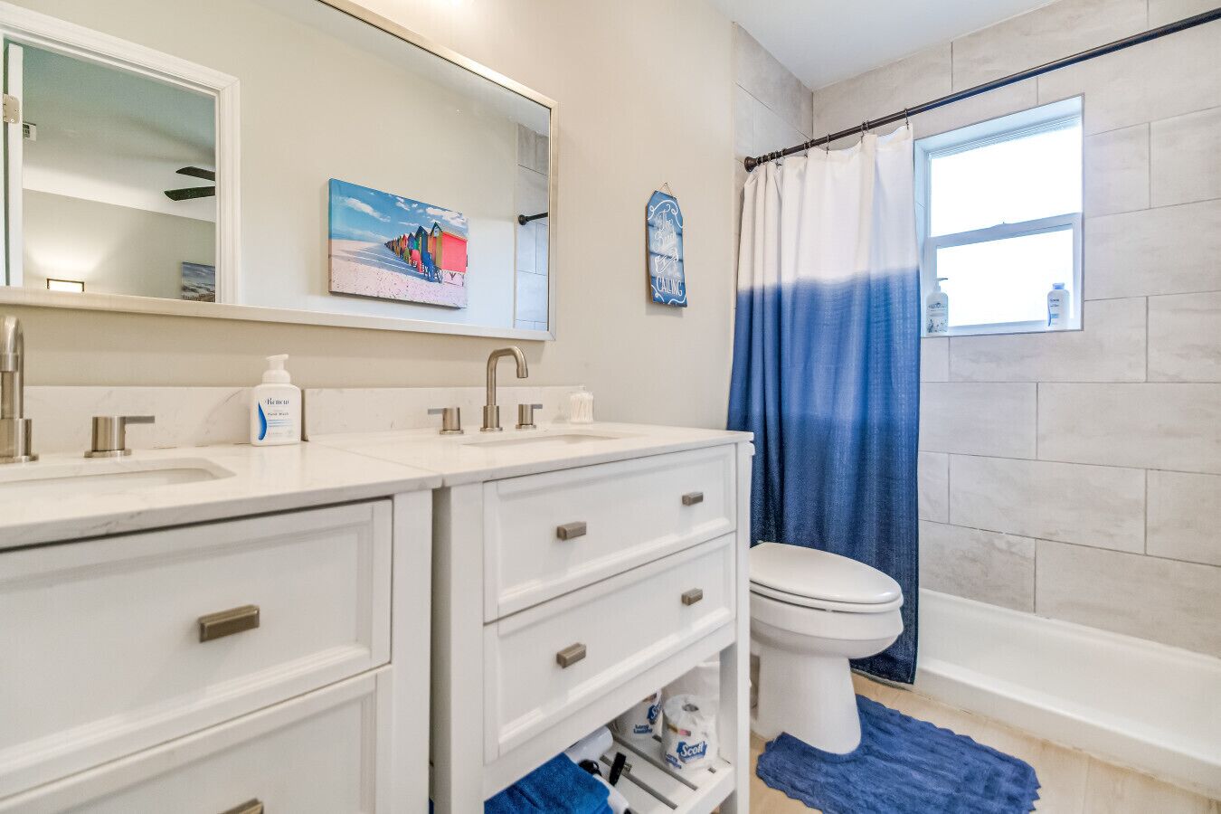 A bathroom with a white vanity, a toilet, and a shower curtain.