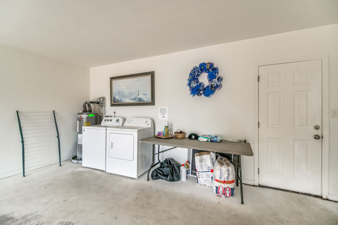 A laundry area with a washing machine, dryer, and a shelf with cleaning supplies.