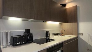 Una cocina moderna con electrodomésticos integrados, una encimera y un perchero para toallas.