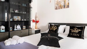 A hotel room with a bed, a wardrobe, a nightstand, and a wall art piece.