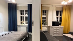 Ein modernes Hotelzimmer mit Bett, Schreibtisch, Stuhl und Fernseher.