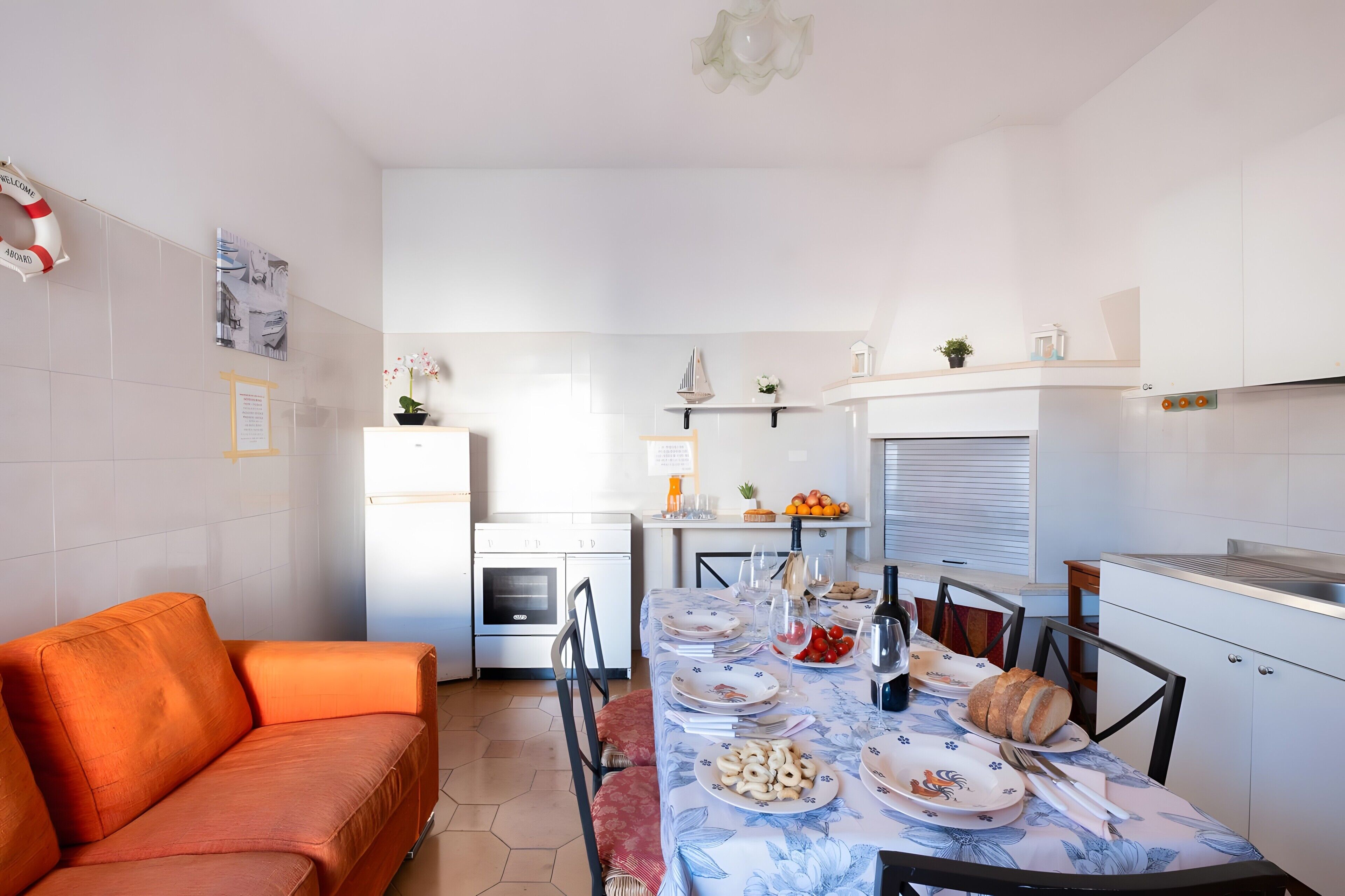 A compact living space with a dining table set for a meal, a kitchenette, and a sofa.