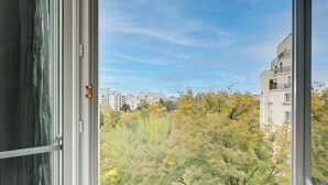 A view from a window with a view of trees and buildings in the distance. - Modern 3BR Apartment with Balcony - Pereire (Paris)