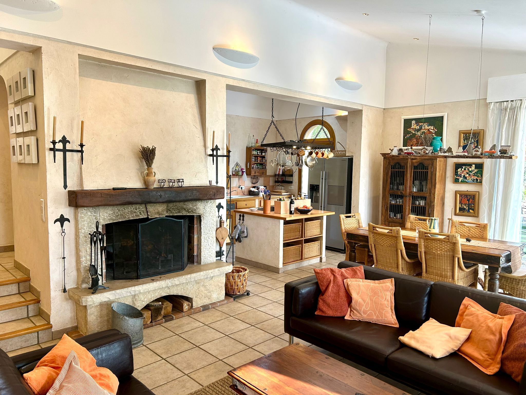 Un salón amplio con chimenea, un comedor y una cocina al fondo.