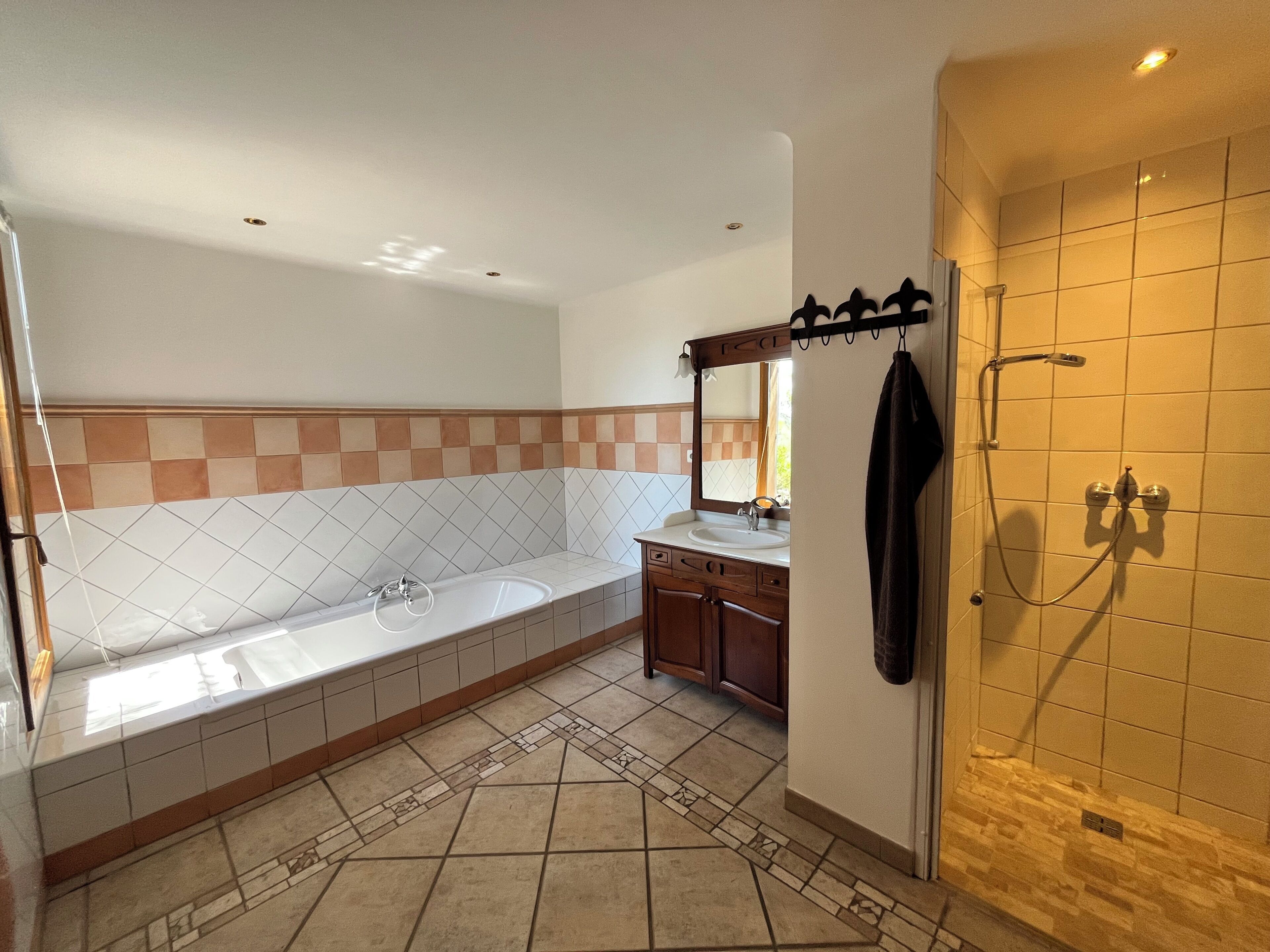 Ein Badezimmer mit Badewanne, Waschbecken, Spiegel und Dusche.