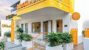 A modern hotel with a yellow facade and a sign reading "bloomhotel". - Bloom Hotel - M Block GK2 (New Delhi)