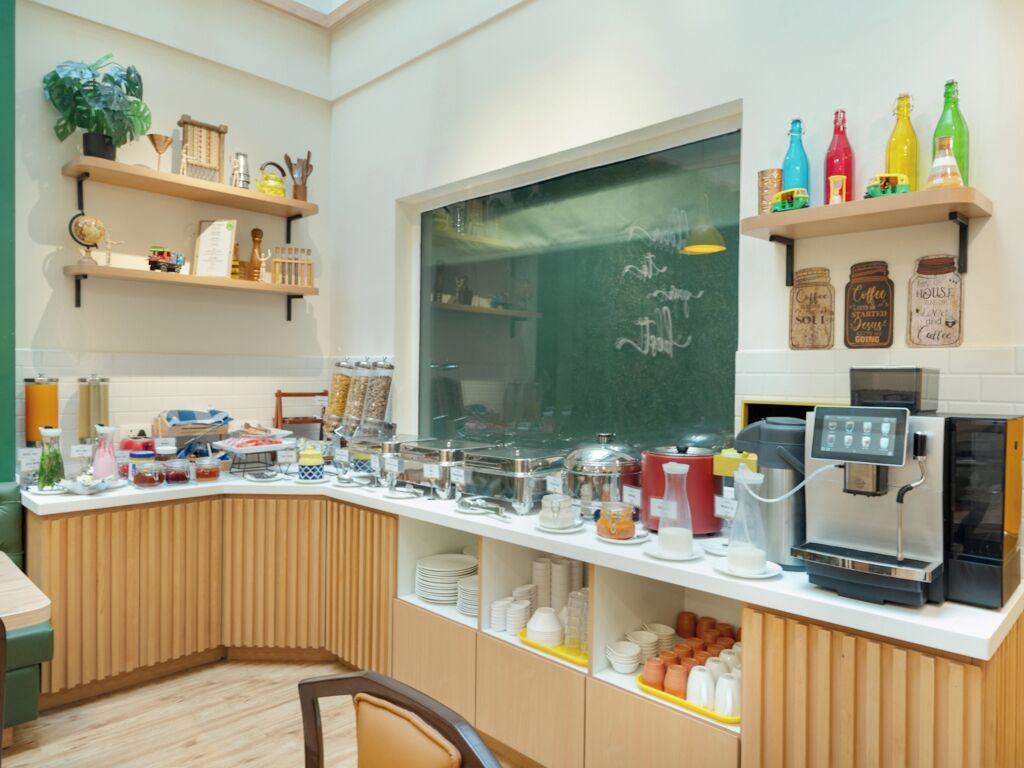 A breakfast bar with various food items and a coffee machine.