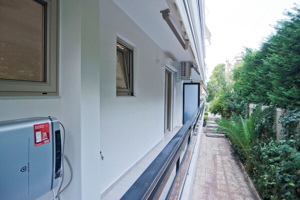A narrow corridor with a window on the left and a door on the right, leading to a staircase.