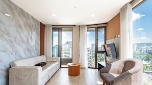 A modern living room with a sofa, armchair, and a round coffee table. - Edificio Efyra by Host Ecuador (Quito)