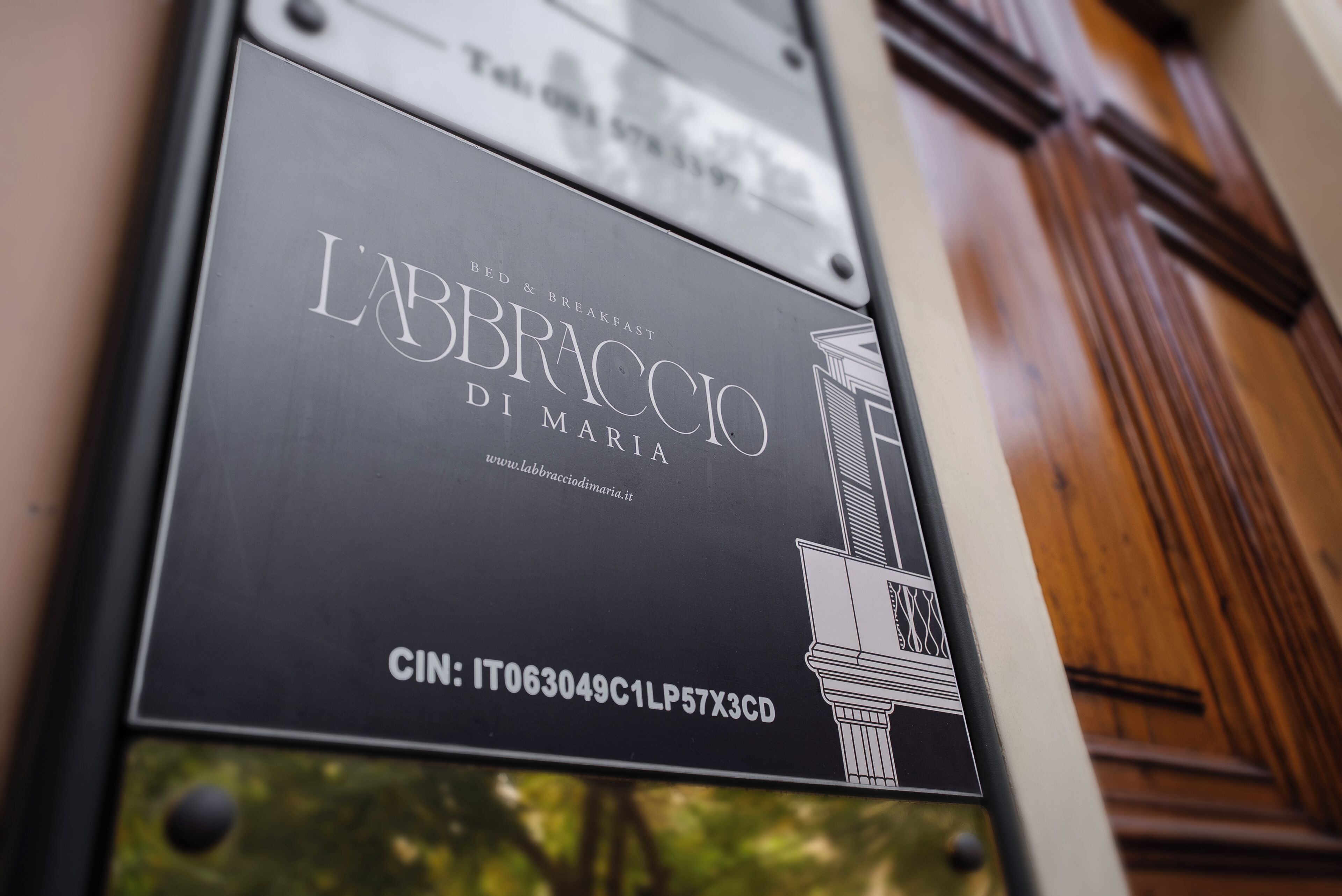 Un letrero que dice 'L'ABBRACCIOLI DI MARIA', con una dirección web y un código CIN.