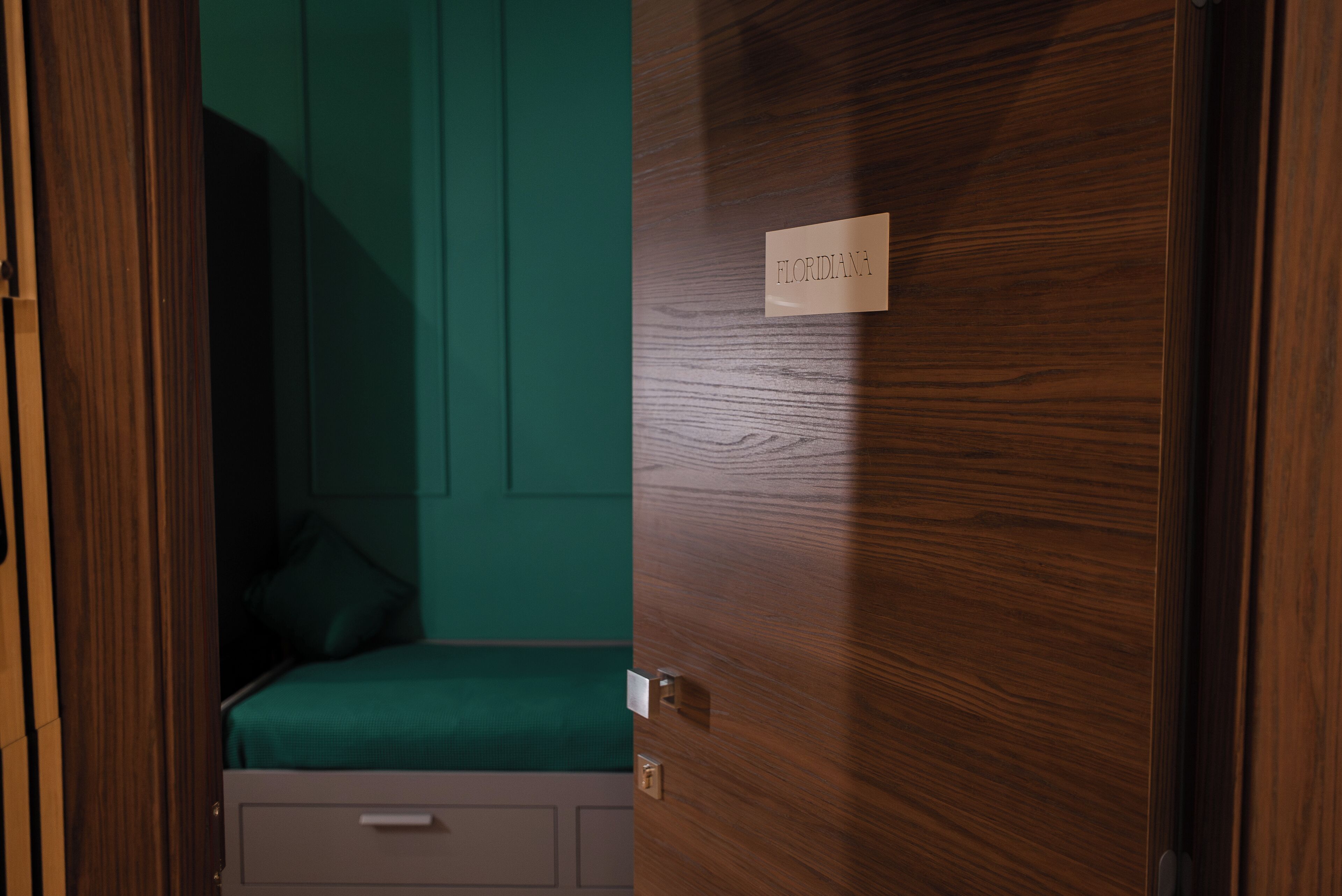 Une chambre avec un lit, un bureau et une porte portant l’inscription « FLORIDANA ».