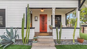 A white house with a red door, cacti, and a small porch. - 2 Side-by-Side San Diego Homes w/ Shared Backyard, Firepit & BBQ (San Diego)