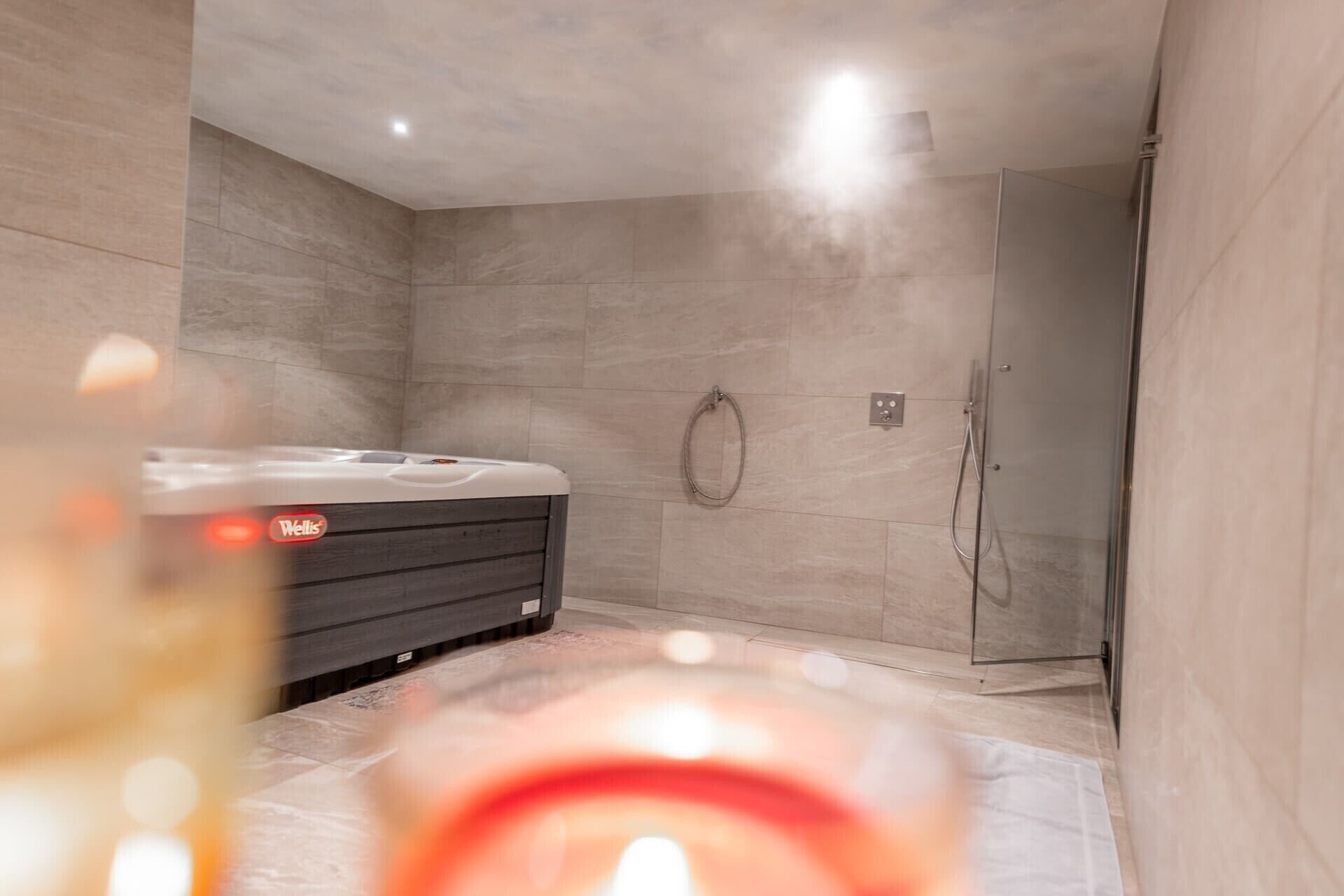 Un bagno moderno con vasca idromassaggio, doccia e box doccia in vetro.