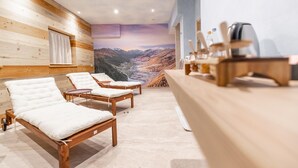 A spa room with wooden walls, a massage table, two sun loungers, a massage table with a view of mountains, and a reception desk. - 'Imbosc'ché Bnb Argento' Room with Mountain View, Shared Garden & Wi-Fi (Teola)