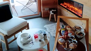 Una habitación acogedora con chimenea, una mesa de comedor con desayuno y una silla.