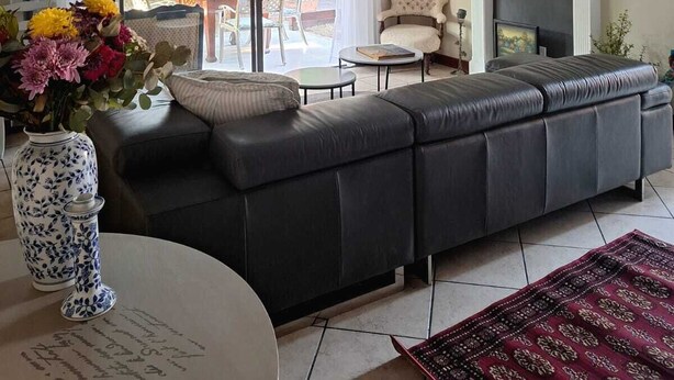 A living room with a sofa, a fireplace, and a dining area with a table and chairs.