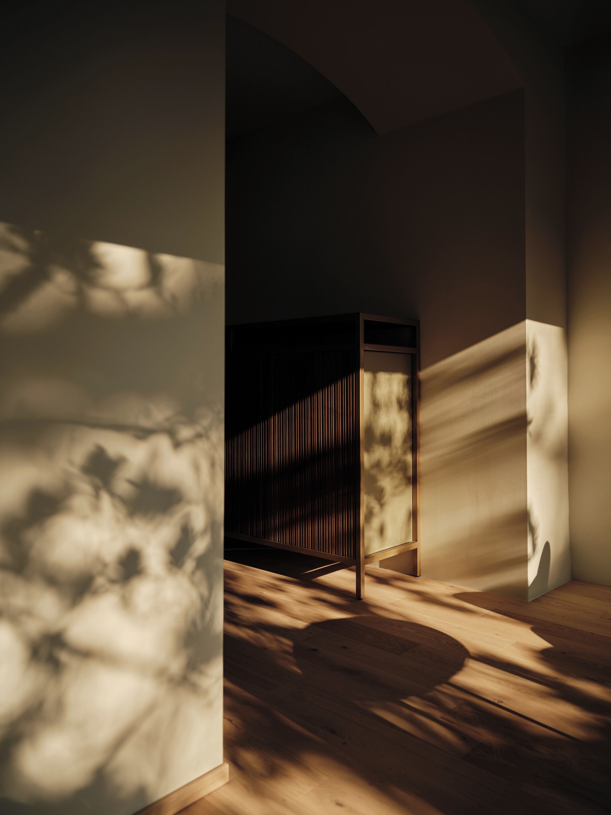 Ein Zimmer mit Holzboden, einem dunklen Schrank und einem großen Fenster, das Schatten wirft.