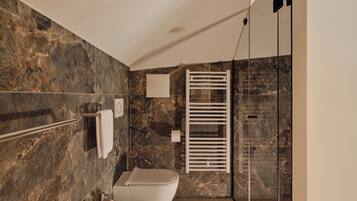 Ein modernes Badezimmer mit Marmorwand, Toilette, Waschbecken und einer Duschkabine aus Glas.