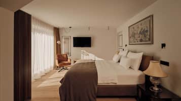 A modern hotel room with a large bed, a desk, a chair, and a TV.