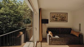 Un soggiorno moderno con un divano marrone scuro, un quadro appeso al muro e vista su alberi attraverso una porta in vetro.