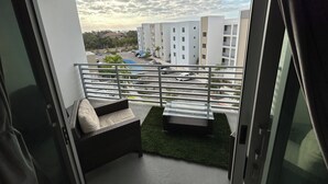 A balcony with a view of a parking lot and buildings.