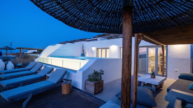 A modern outdoor pool area with lounge chairs and a pergola.