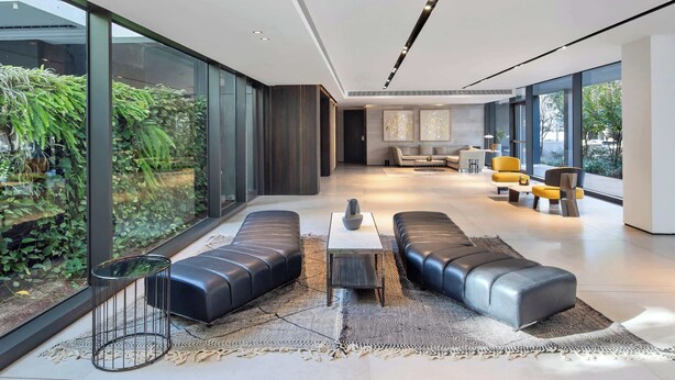Una sala de estar moderna con un amplio ventanal, sofás de cuero y un diseño minimalista.