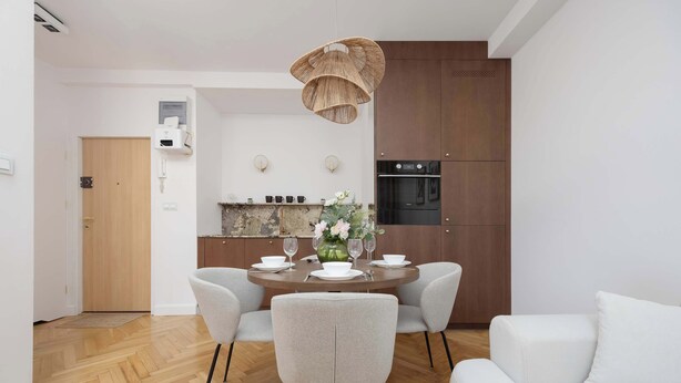 Una cocina moderna con comedor, que incluye una mesa redonda, sillas y una lámpara colgante.
