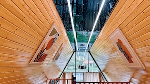 A wooden interior with a wooden railing and a view through a large window. - Dekoriza Glamping  (Ismailli)