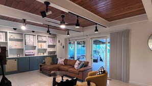 Una sala de estar moderna con un sofá seccional, dos sillones, una mesa de centro y una unidad de estanterías empotradas con objetos decorativos.