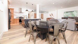 Een moderne keuken met een centraal eiland, houten kastjes en roestvrijstalen apparatuur.