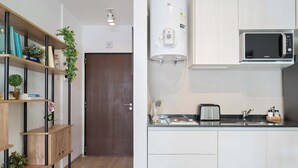 Una cocina moderna con microondas integrado, calentador de agua y tostadora en la encimera.