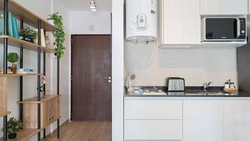 Una cocina moderna con microondas integrado, calentador de agua y tostadora en la encimera.