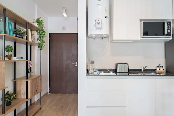 Eine moderne Küche mit integriertem Mikrowellenherd, Durchlauferhitzer und Toaster auf der Arbeitsfläche.