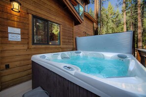 Una cabaña de madera con jacuzzi y ventana.