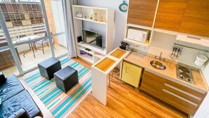 A compact living space with a kitchenette, a dining area, and a seating area with a view to the outside. - Maximus Luxury in Nyc Berrini (São Paulo)