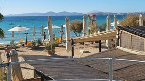 A beachside view with umbrellas, lounge chairs, and a playground. - Poseidon Executive Suite in the heart of Athens Riviera. Edem beach and marina. (Paleo Faliro)