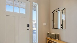 A hallway with a white door, a bench, and a mirror on the wall. - NEW Ivy Streat Retreat in Ephrata, Sleeps 10, EV Charger + Foosball + Air Hockey (Ephrata)