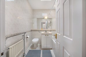 Un baño con inodoro, lavamanos y ducha.