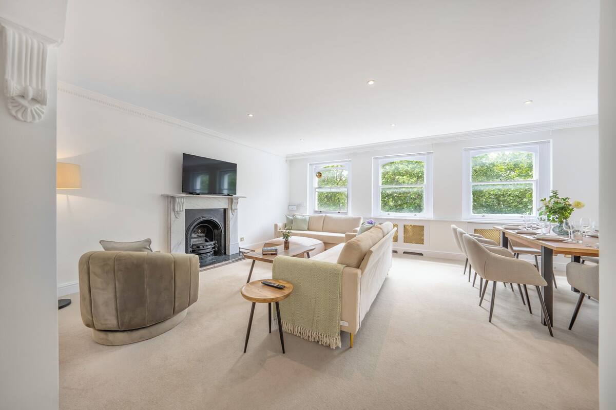 A spacious living room with a fireplace, sofa, and dining area.