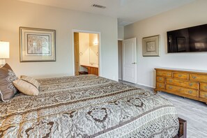 Un dormitorio con una cama grande, un aparador y un espejo.