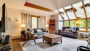 A spacious living room with a large window, a fireplace, and a cozy seating area. - 6 Mi to Okemo! Family Townhome in Lakeside Resort (Plymouth)