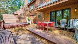 A wooden deck with a table and chairs, a hot tub, and a covered patio area. - 6 Mi to Okemo! Family Townhome in Lakeside Resort (Plymouth)