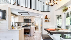 A spacious kitchen with wooden cabinets, a large island, and a dining area with a bench. - Pet-friendly Show Low Cabin w/ Trail Access! (Show Low)
